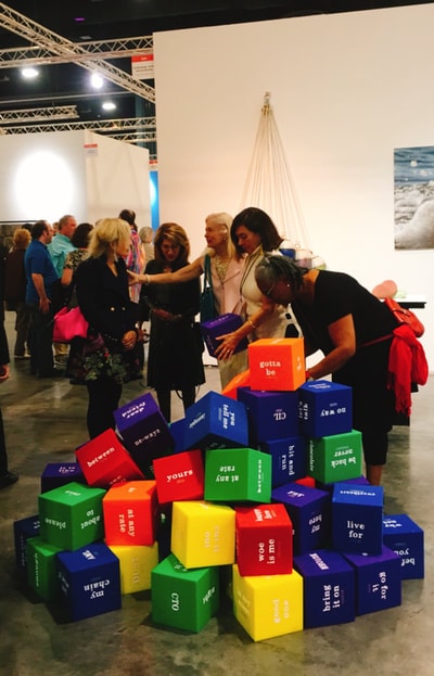 Visitors engaging with colorful cubes installation at art fair
