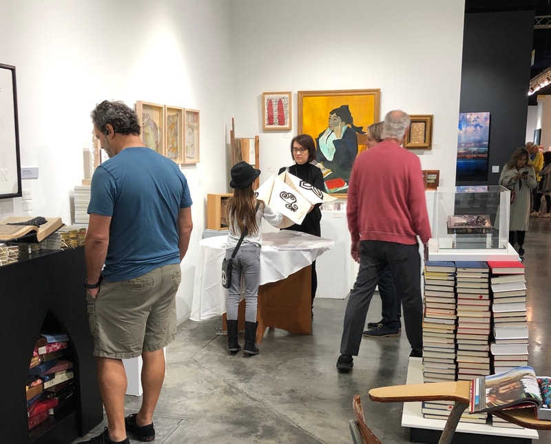 Gallery visitors exploring the collaboration book installation