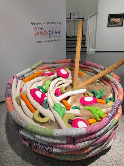 Play With Your Food — large fabric bowl sculpture with soft food items, gallery installation