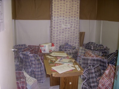 Shelter room with donated clothing bags and supplies on display — HomeBase Project